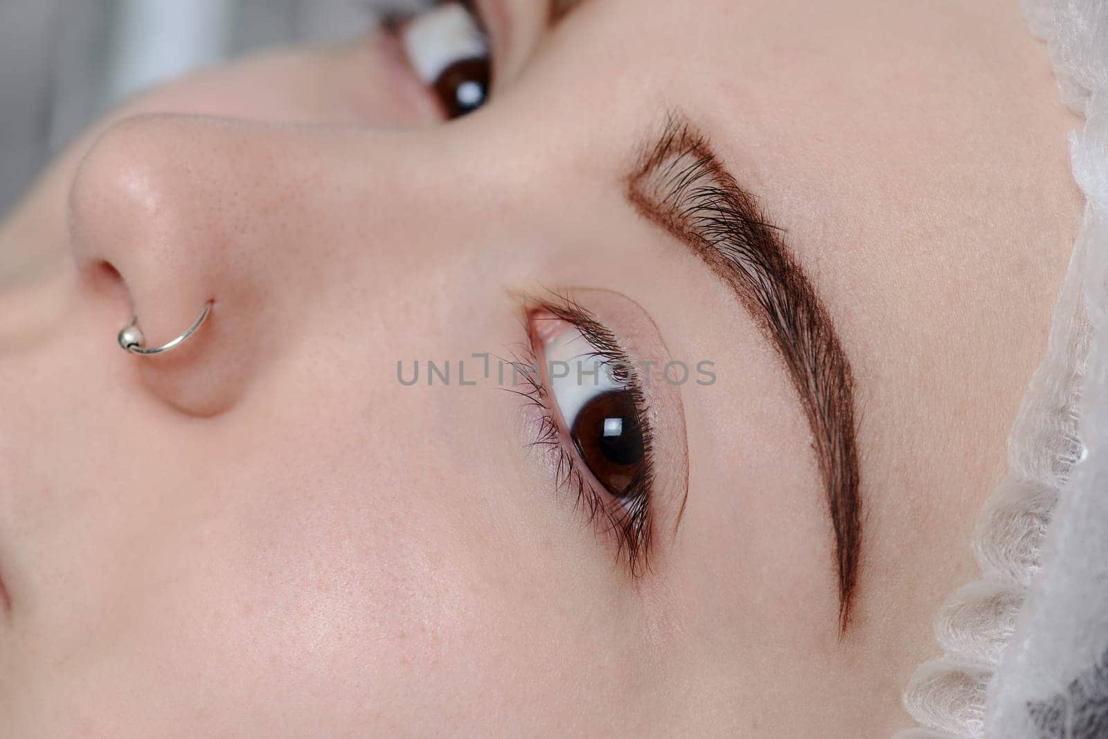 Permanent makeup. Permanent tattooing of eyebrows. Cosmetologist applying permanent make up on eyebrows- eyebrow tattoo