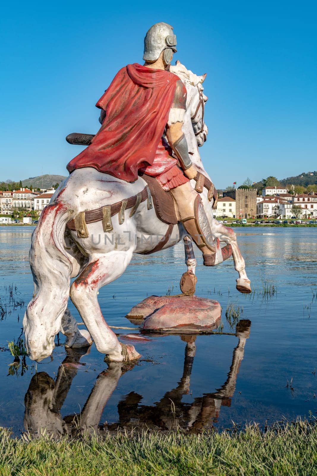 PONTE DE LIMA, PORTUGAL - CIRCA APRIL 2018: Statue of Roman soldier in front of the Roman bridge crossing the Rio Lima in Portugal.