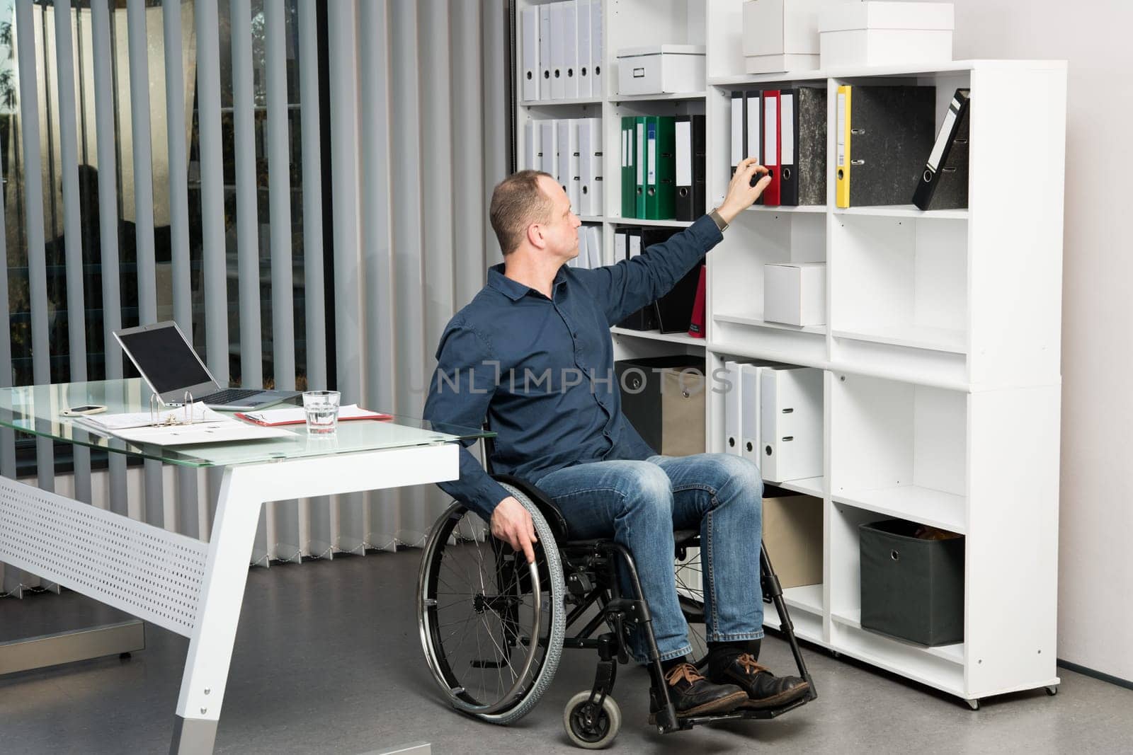 disabled businessman in wheelchair taking a folder in the office