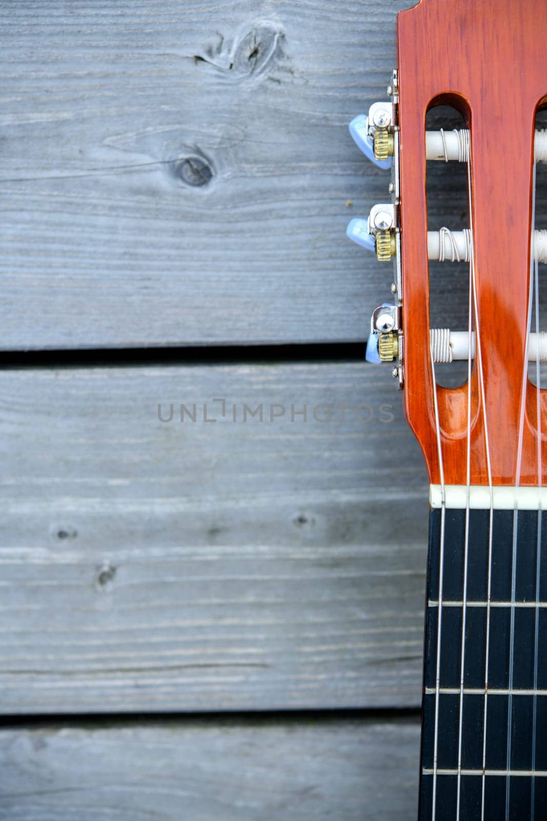 close up of a acoustic guitar neck on wooden ground