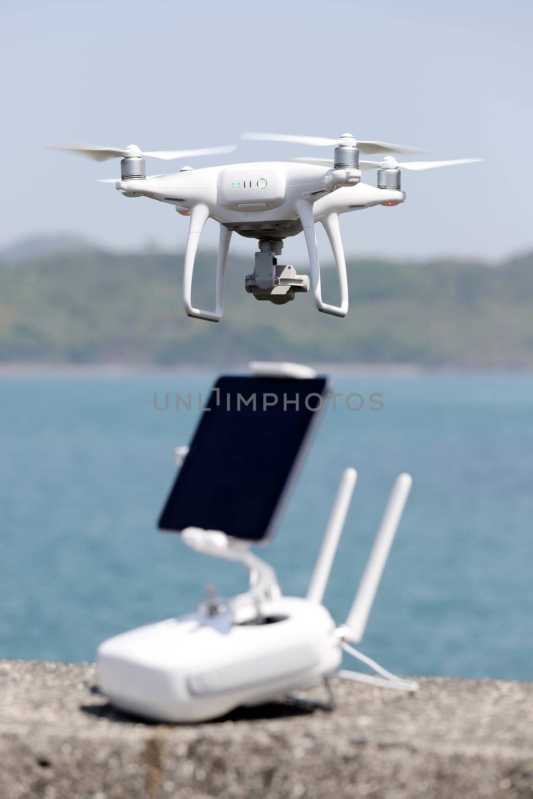 drone and remote controller with monitor on concrete jetty