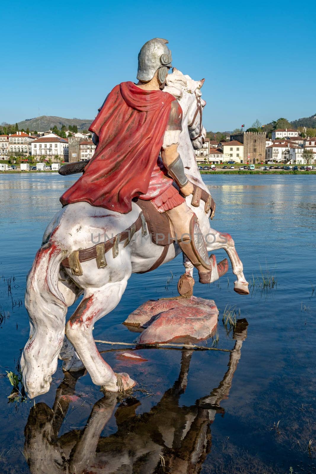 PONTE DE LIMA, PORTUGAL - CIRCA APRIL 2018: Statue of Roman soldier in front of the Roman bridge crossing the Rio Lima in Portugal.