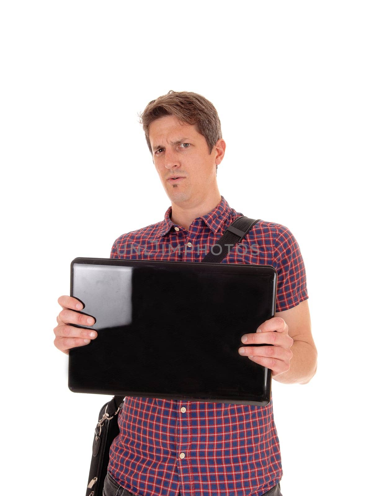 A suspicious man in a checkered shirt holding up his laptop questioning.what he sees on the screen, isolated for white background.