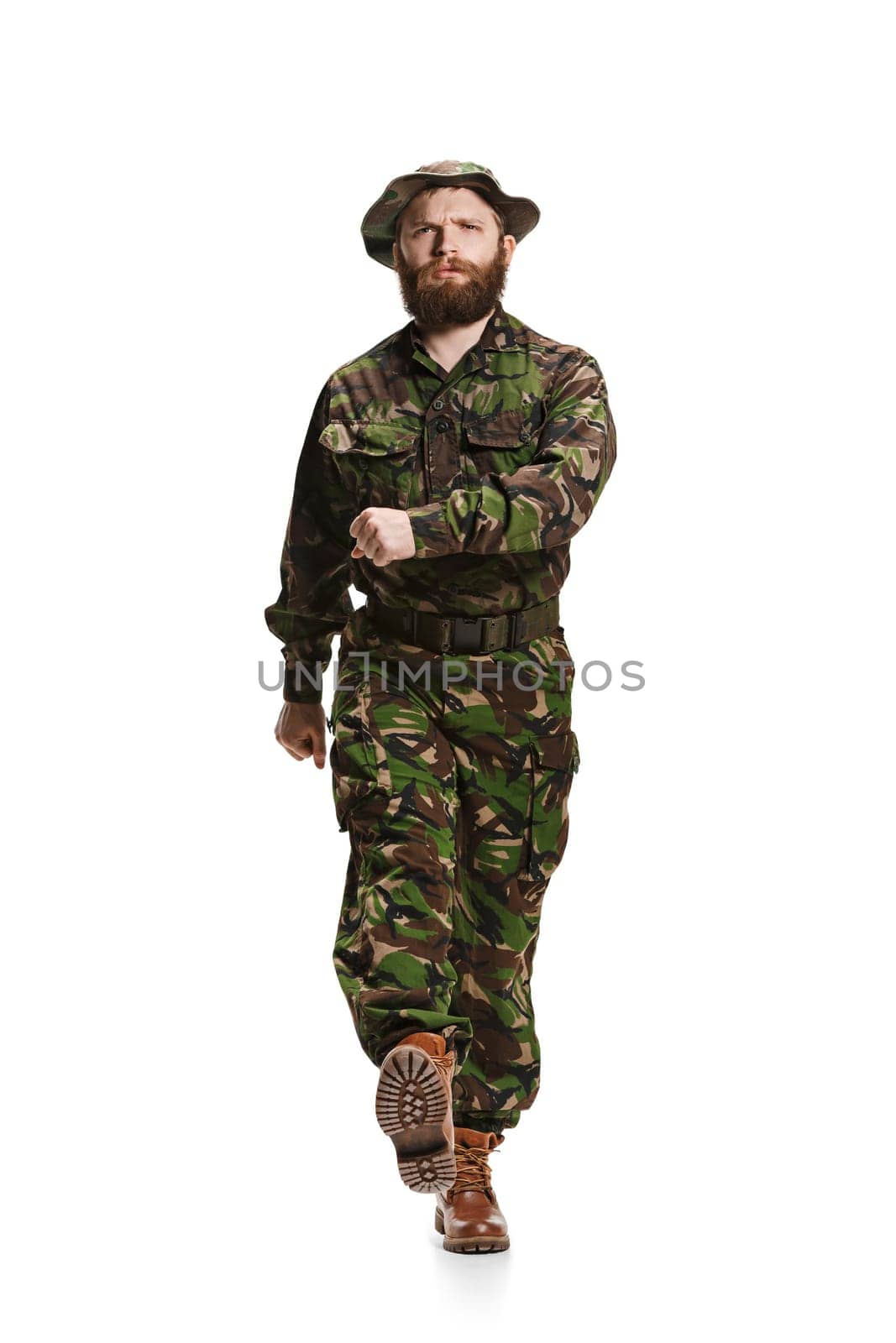 Young army soldier wearing camouflage uniform going isolated on white studio background in full-length. Young caucasian model. Military, soldier, army concept. Proffeshional concepts