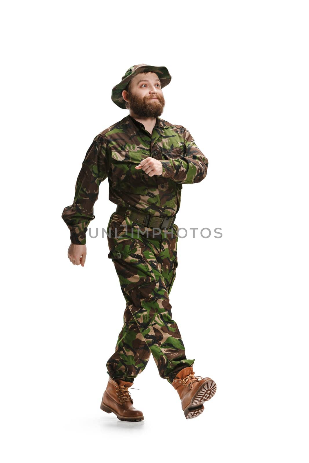 Young army soldier wearing camouflage uniform going isolated on white studio background in full-length. Young caucasian model. Military, soldier, army concept. Proffeshional concepts
