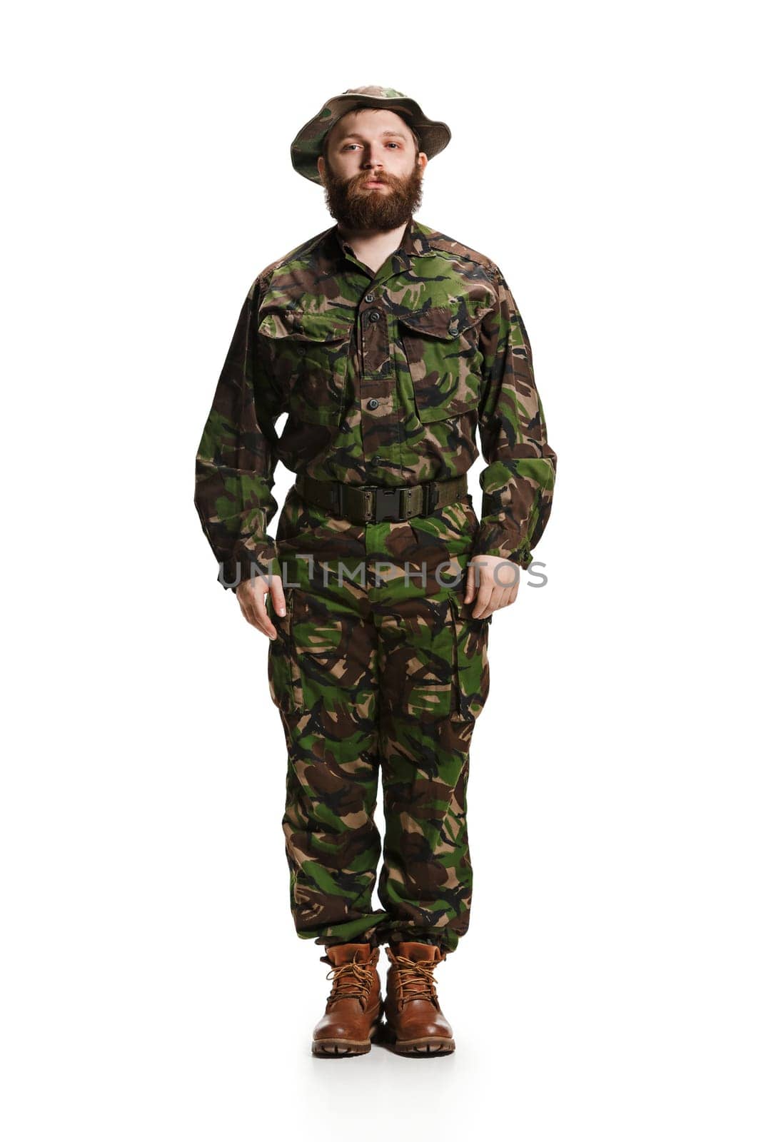 Young army soldier wearing camouflage uniform isolated on white studio background in full-length. Young caucasian model. Military, soldier, army concept. Proffeshional concepts