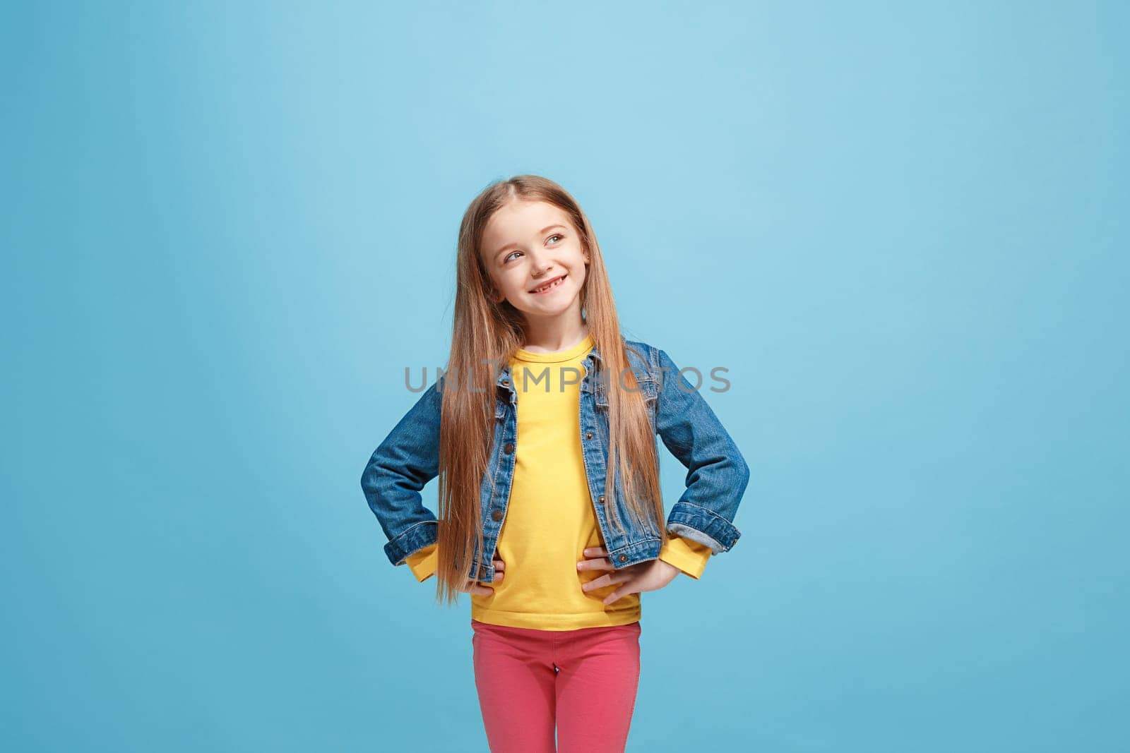 Happy teen girl standing, smiling isolated on trendy pink studio background. Beautiful female half-length portrait. Human emotions, facial expression concept.