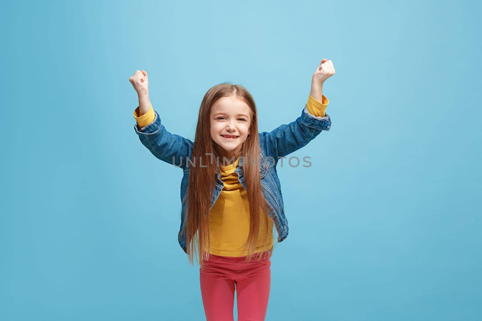 I won. Winning success happy teen girl celebrating being a winner. Dynamic image of caucasian female model on blue studio background. Victory, delight concept. Human facial emotions concept. Trendy colors
