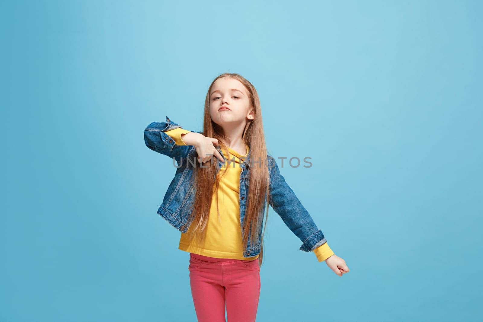 it's me. Serious doubtful, thoughtful teen girl remembering something. Young emotional woman. Human emotions, facial expression concept. Studio. Isolated on trendy blue. Front
