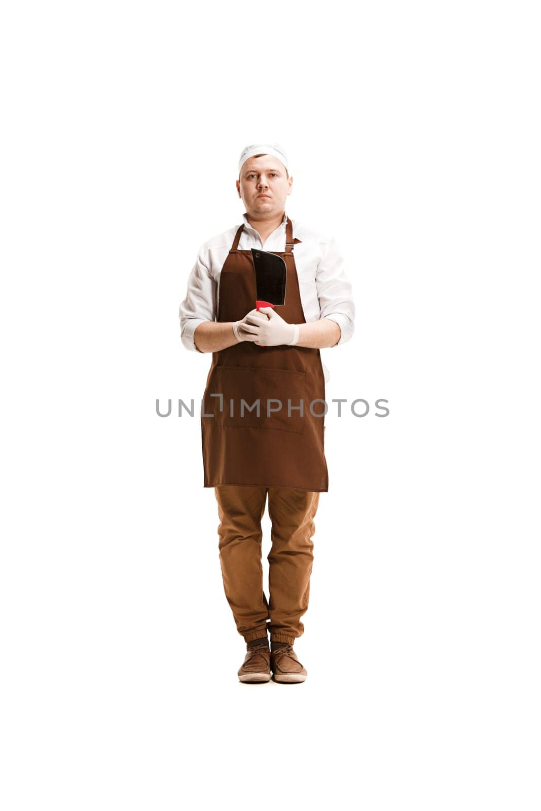 Smiling butcher posing with a cleaver isolated on white studio background. The young caucasian male model in full-length. Butcher, knife, professional concept