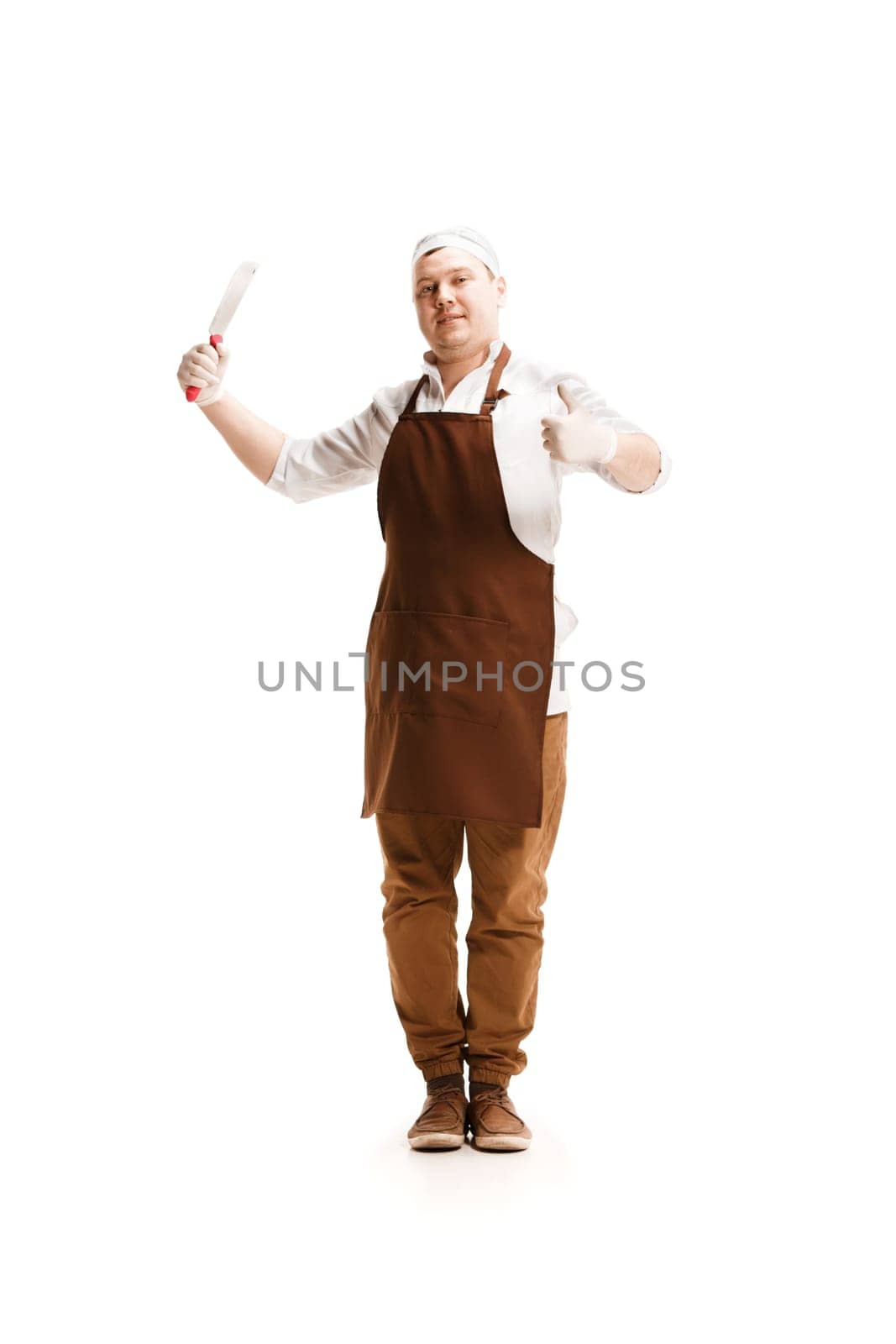 Smiling happy butcher posing with a cleaver isolated on white studio background with sign ok. The young caucasian male model in full-length. Butcher, knife, professional concept