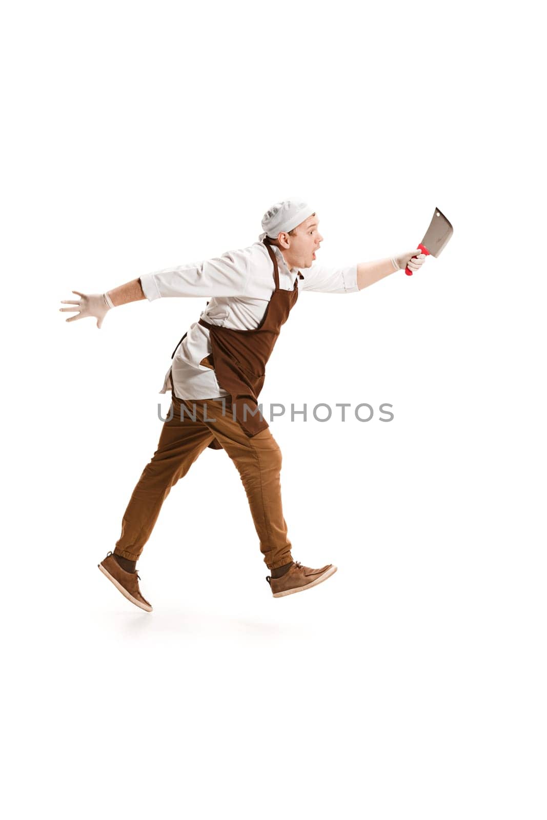 Smiling happy butcher posing with a cleaver isolated on white studio background. The young caucasian male model in full-length. Butcher, knife, professional concept