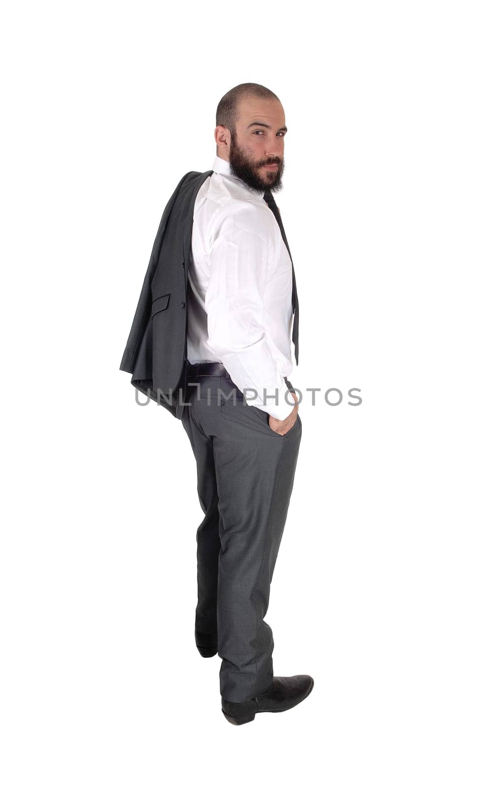 A young handsome business man standing in profile and looking over.his shoulder, with his jacket over his shoulder, isolated over white.