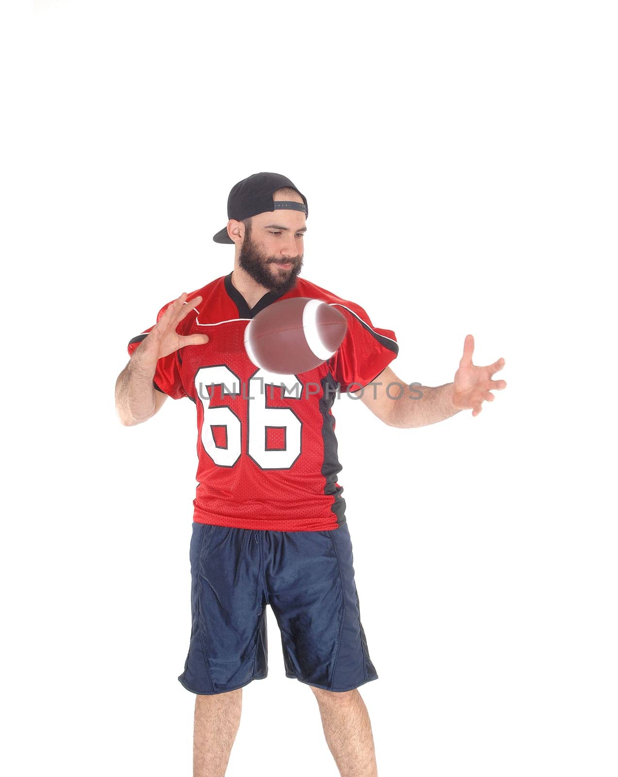 A football player standing and throwing his ball from hand to hand.in his uniform isolated for white background .