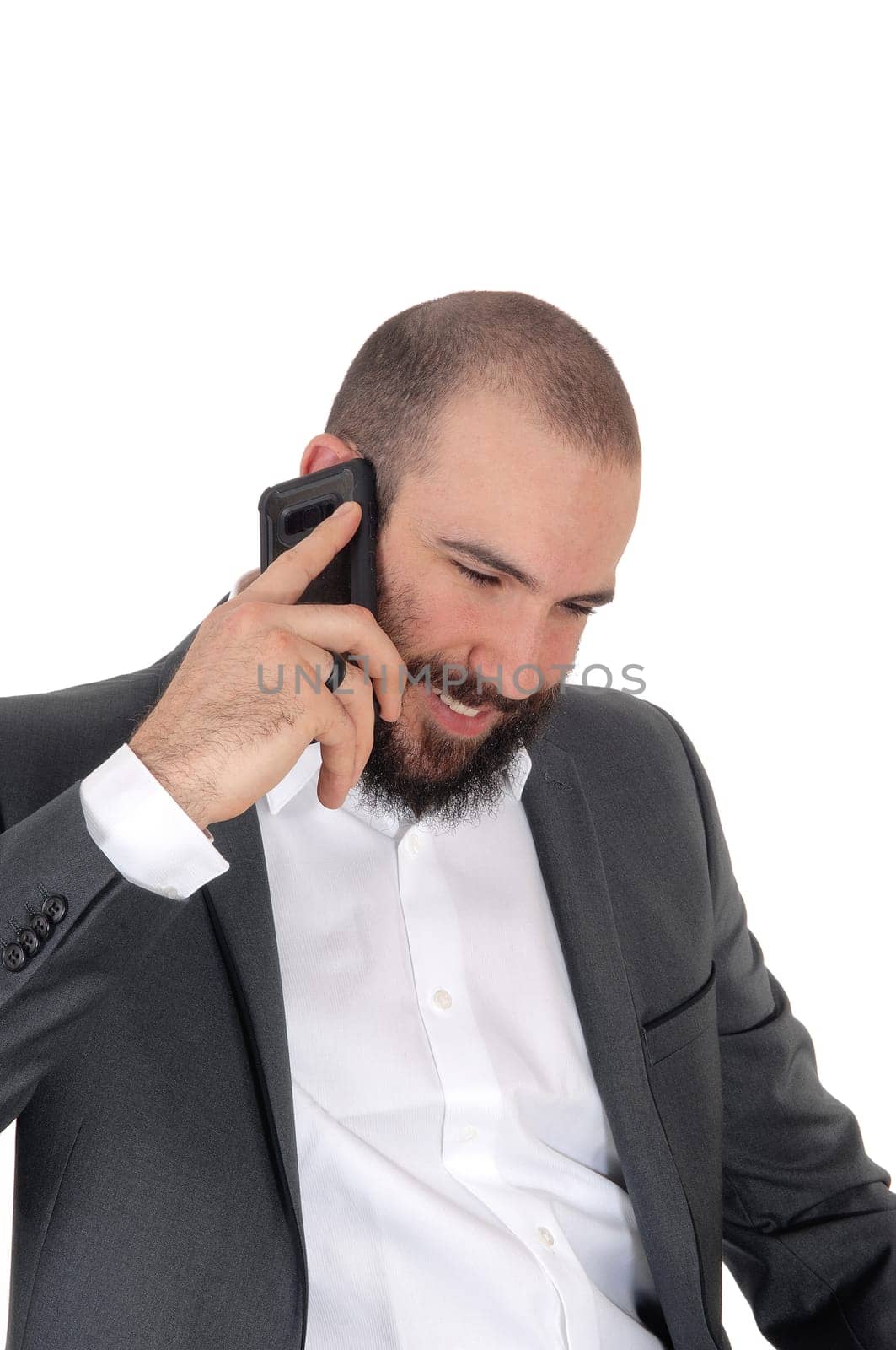 A young man with a beard and mustache in a suit talking on his cell.phone and smiling, isolated for white background.