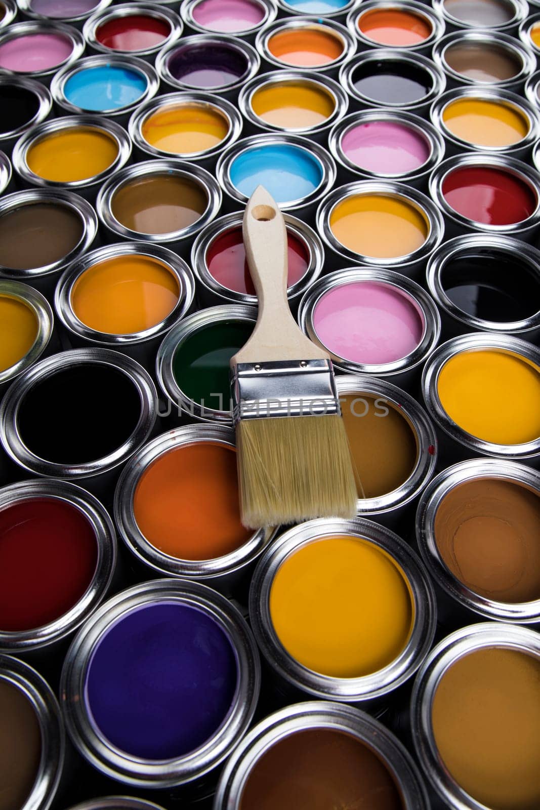 Tin cans with paint, brushes and bright palette of colors