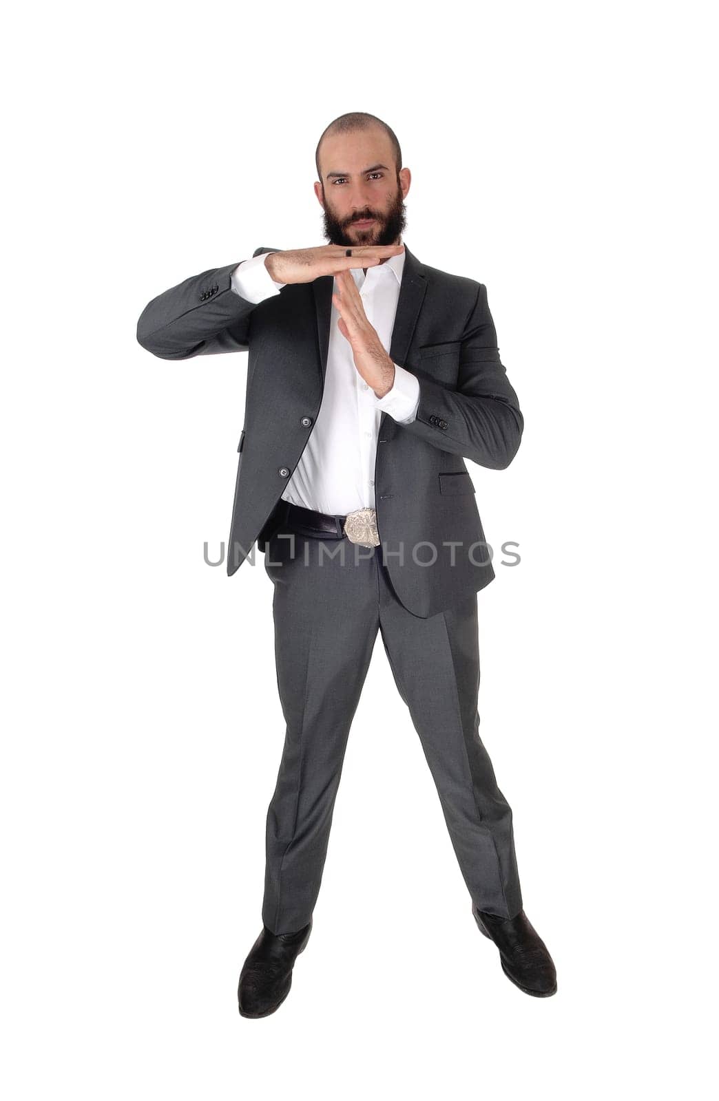 A young tall businessman standing in a suit with a beard and signing.he wants to talk, isolated for white background.