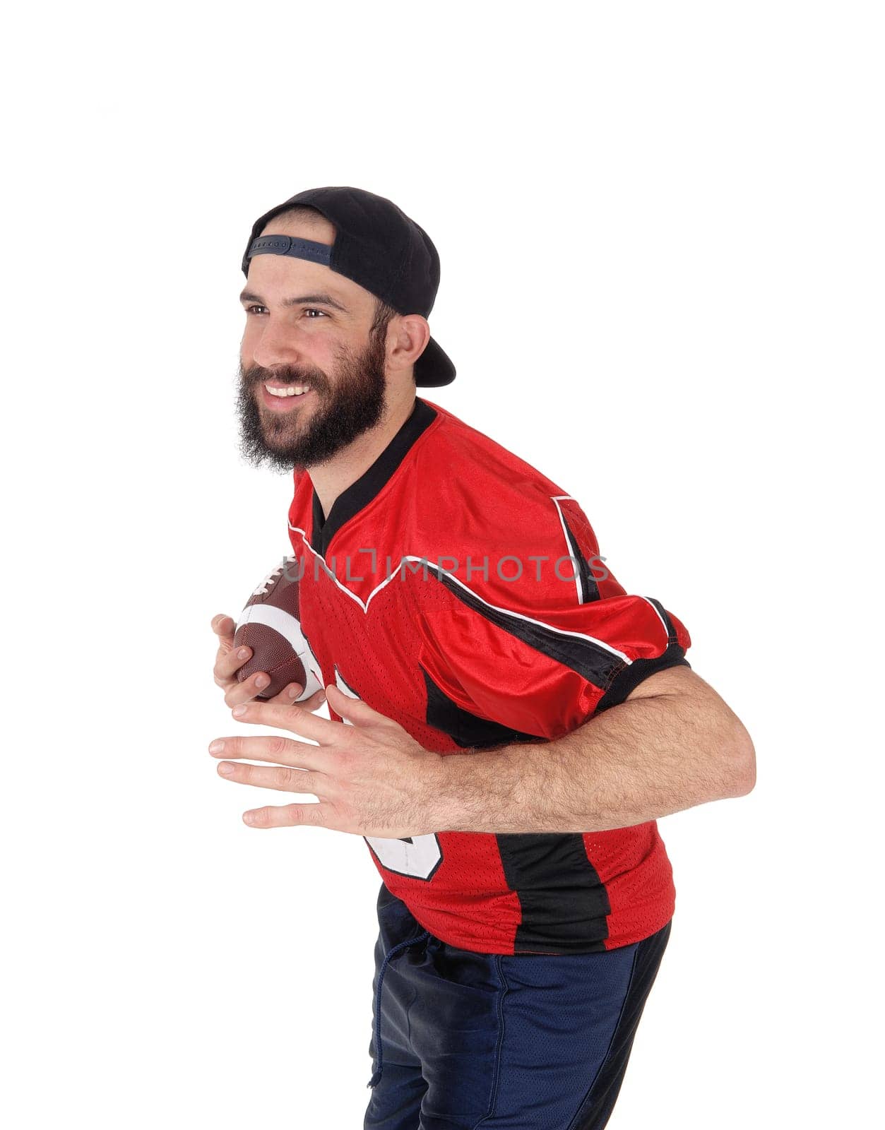 An American football player standing with his ball in his hand in a .close up image, with a beard and mustache, isolated over white.