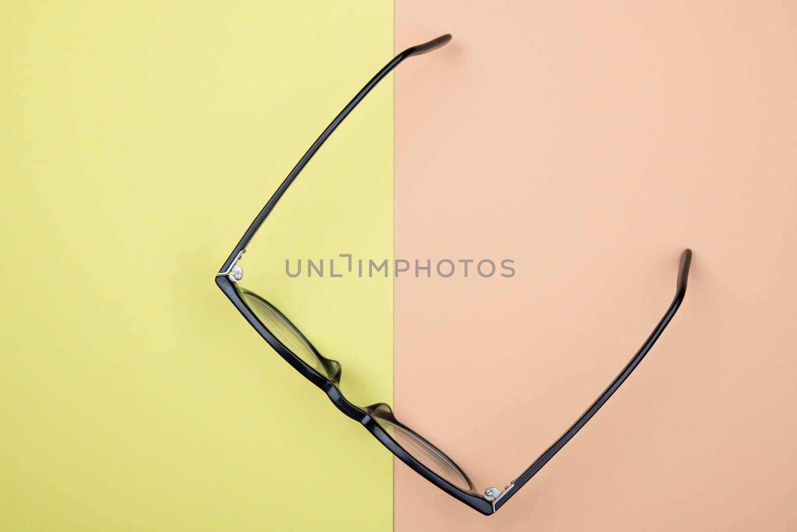 black glasses on yellow and orange ground from above