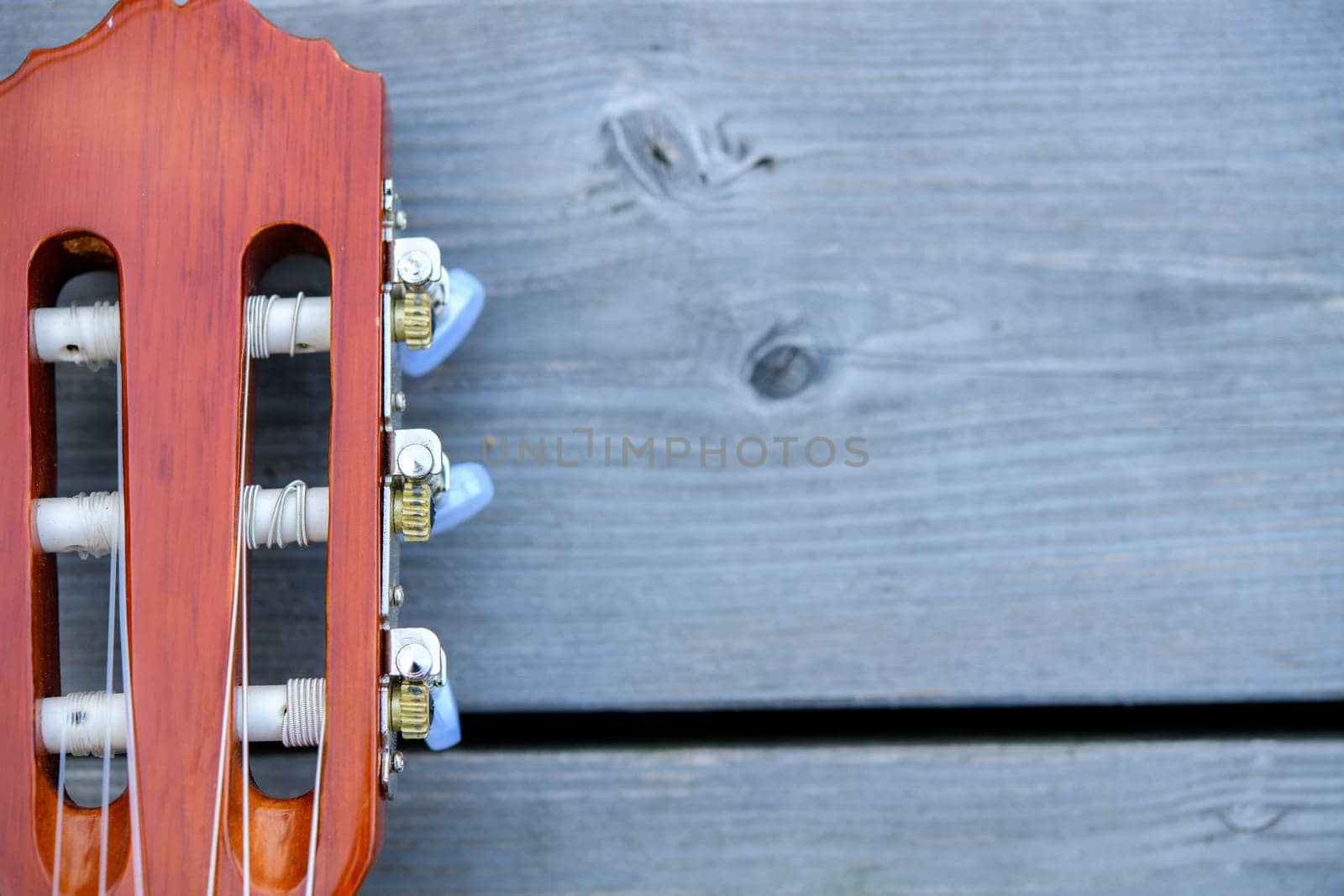 close up of a acoustic guitar neck on wooden ground