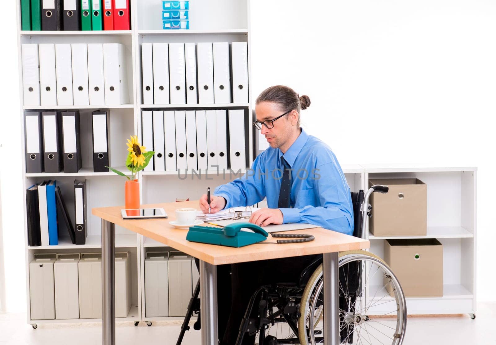 disabled business man in wheelchair is writing