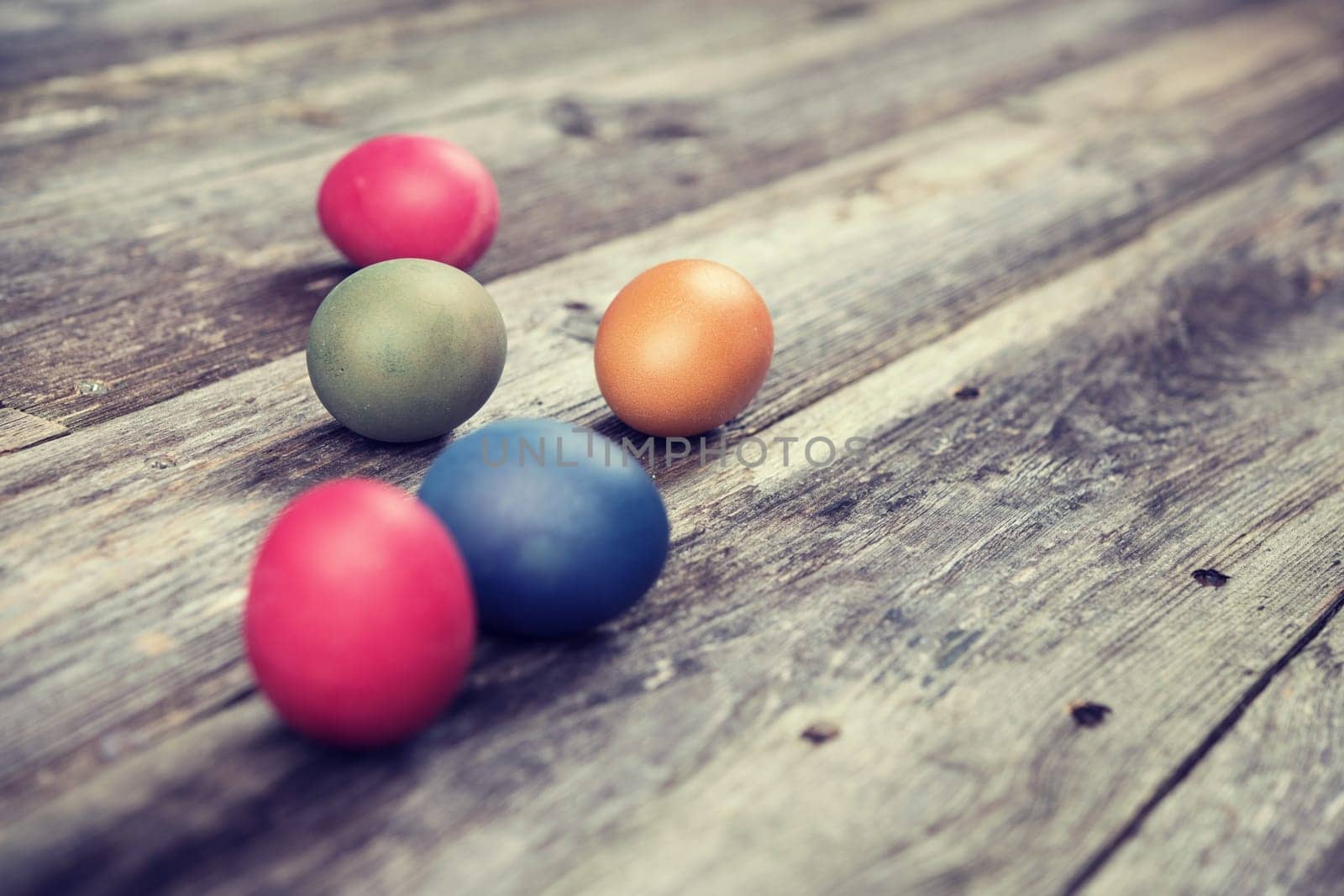different easter eggs on gray wooden ground