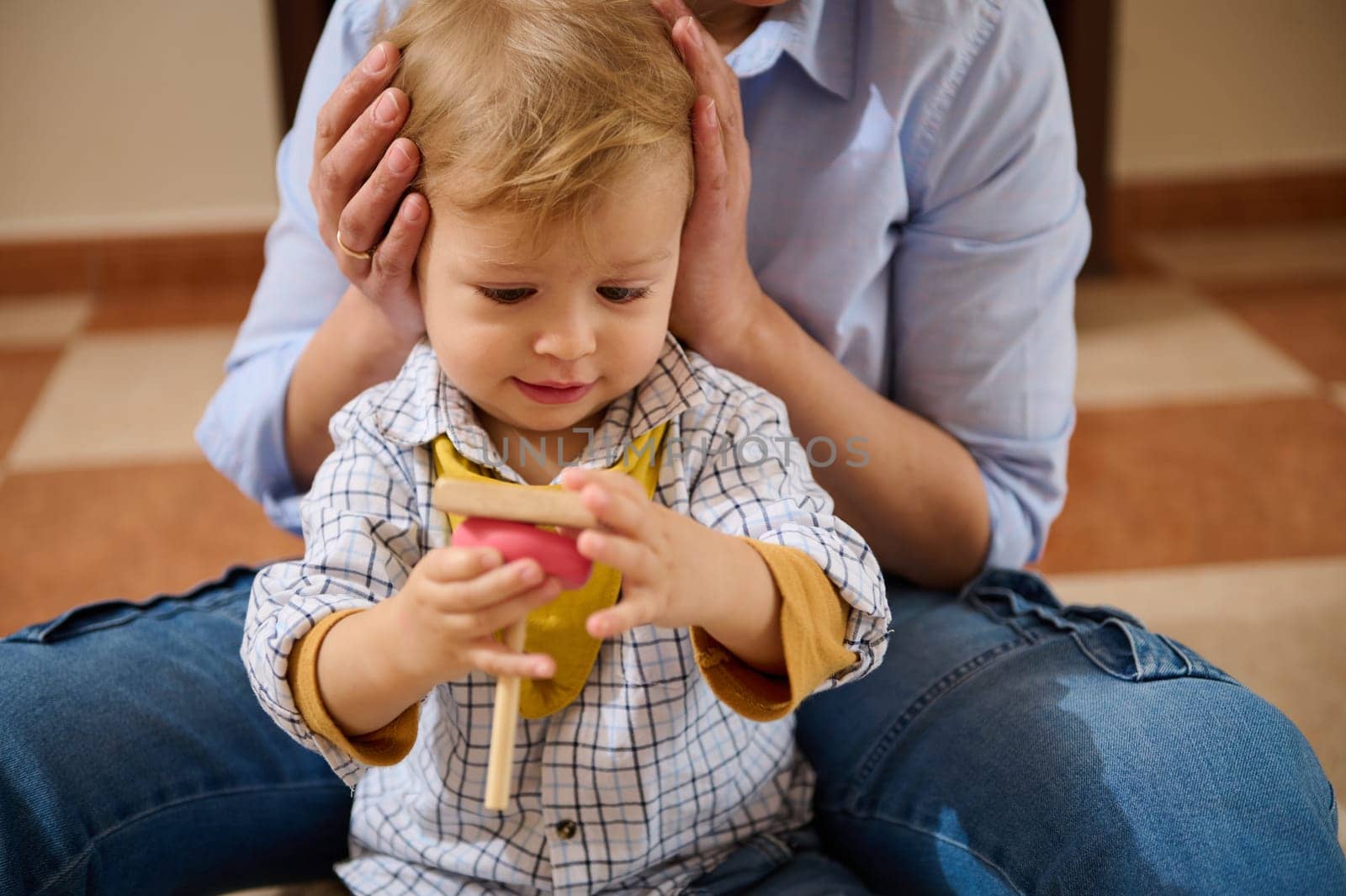 A mother lovingly engages with her young child, encouraging play and exploration. Ideal image for concepts of parenting, family, and emotional bonds.
