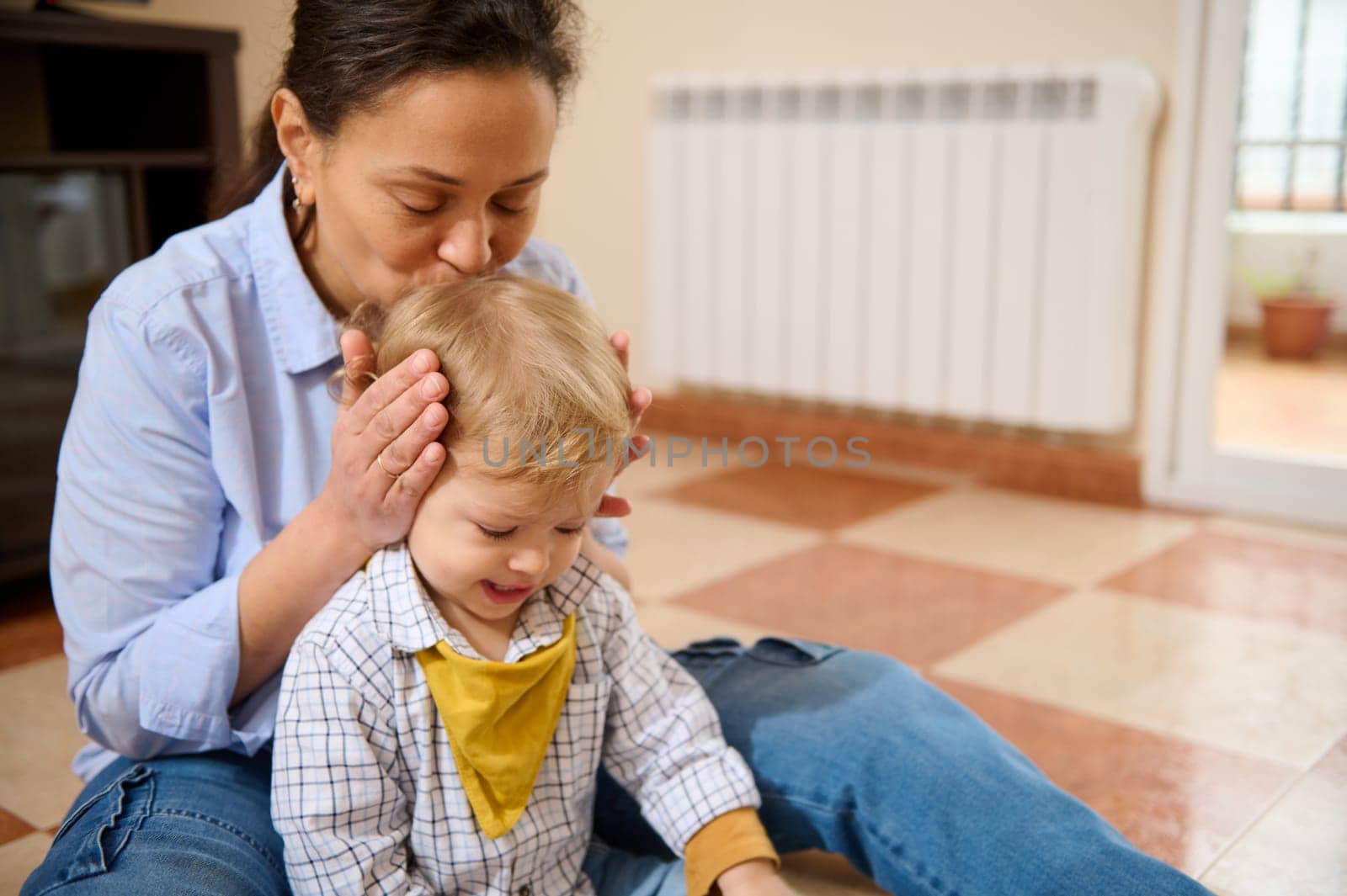 A mother lovingly interacts with her young child, creating a warm and tender family bond at home. Captures the emotional connection and joy of parenting.