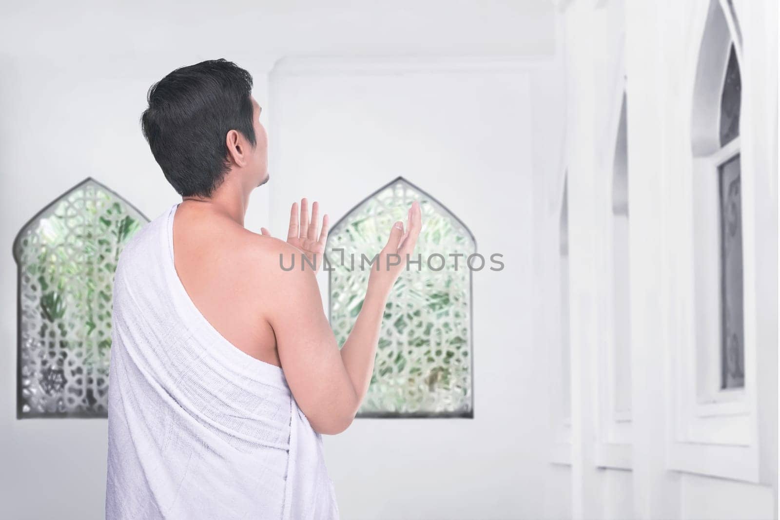 Rear view of asian muslim man pray to god inside the mosque