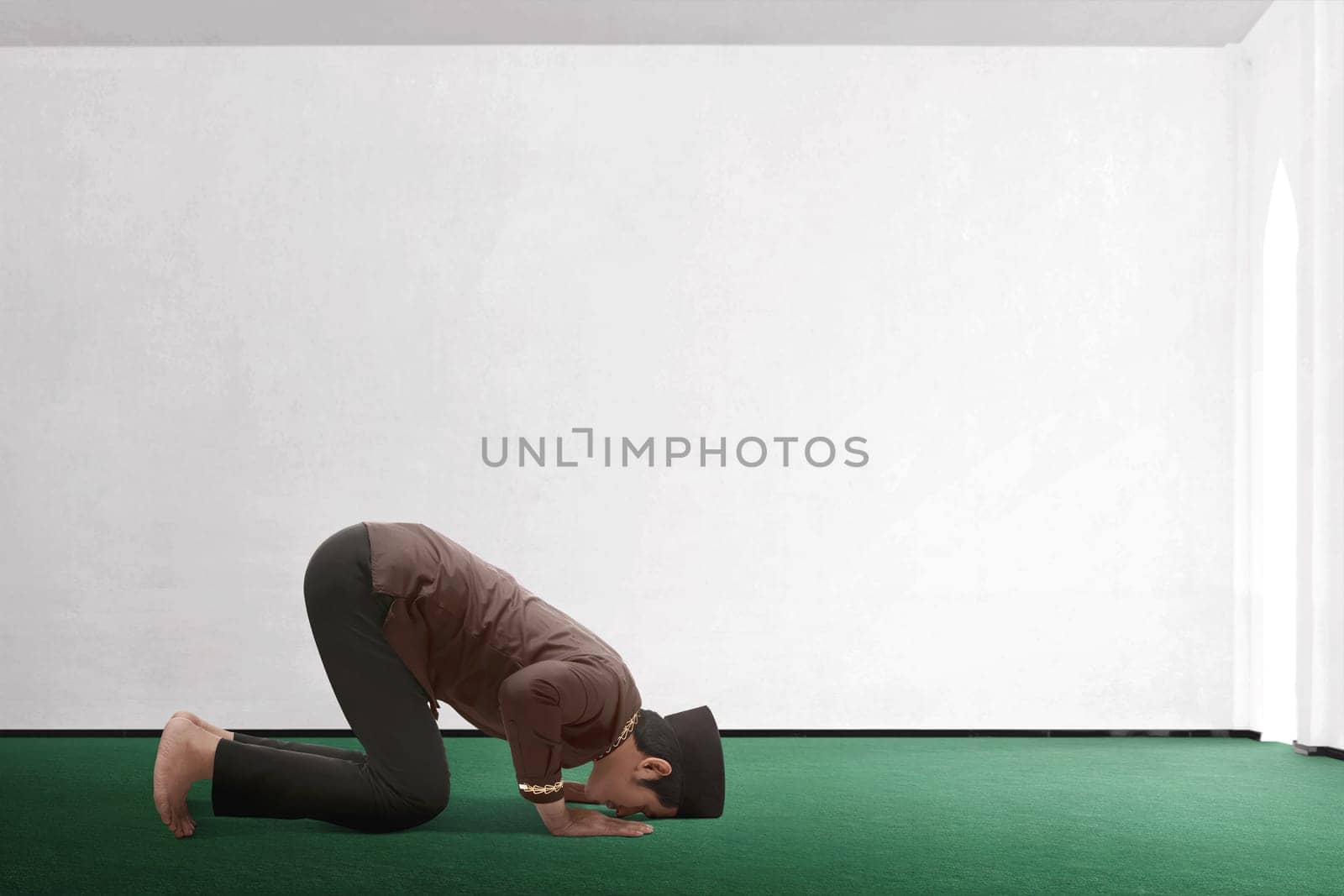 Young asian muslim man praying to god in the mosque