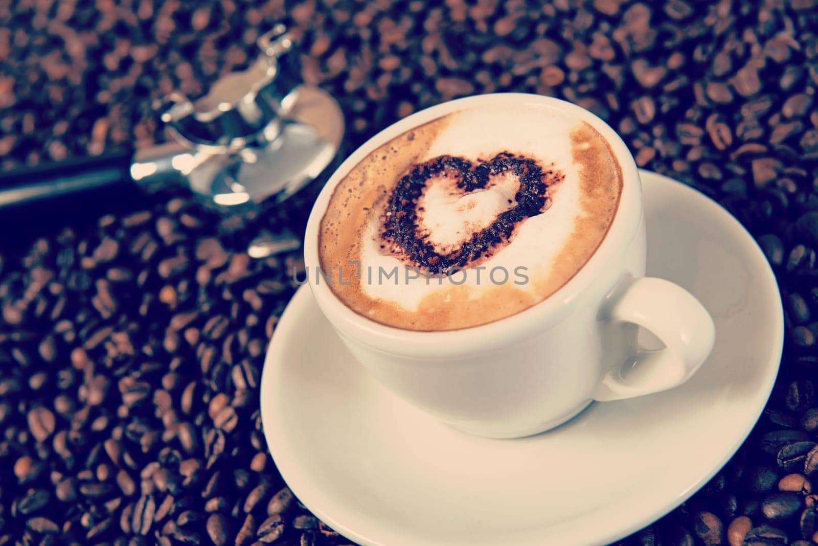 cappuccino with heart on a lot of coffee beans