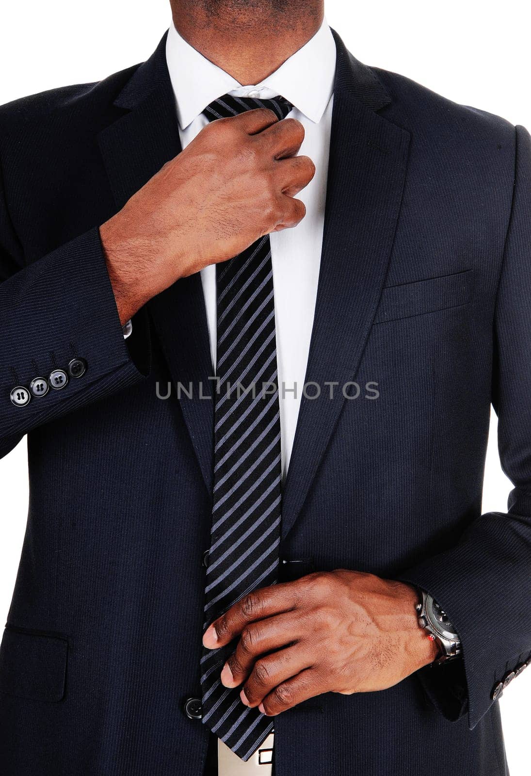 The middle section of an African businessman in a dark suit fixing.his tie, isolated for white background.