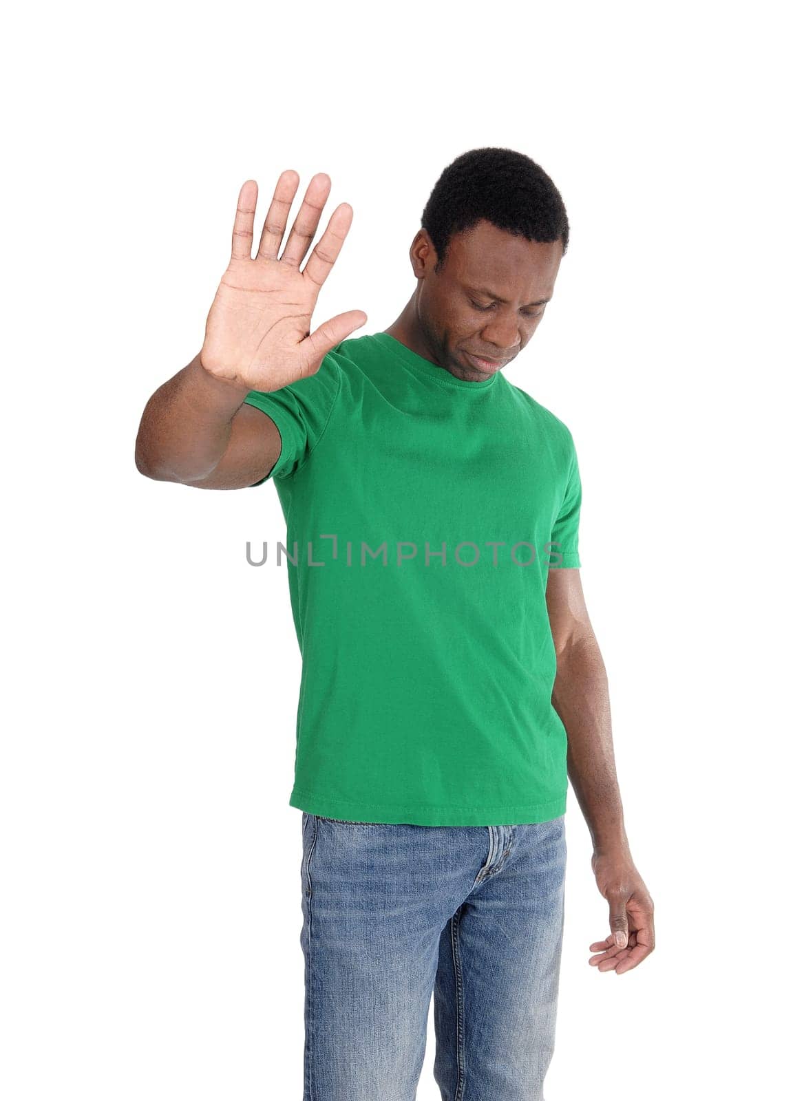 African man standing in jeans and green t-shirt lifting up one hand.saying no, isolated for white background.