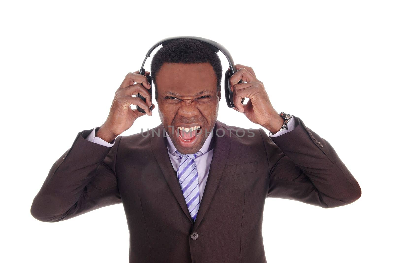 A scared looking African American business man with his headphones .on, listening to music in suit and tie, isolated for white background.