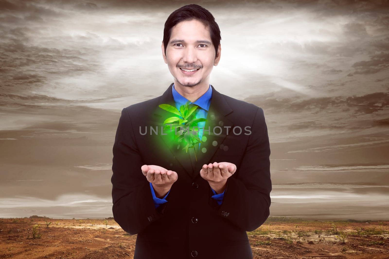 Handsome asian businessman holding plant with climate change background