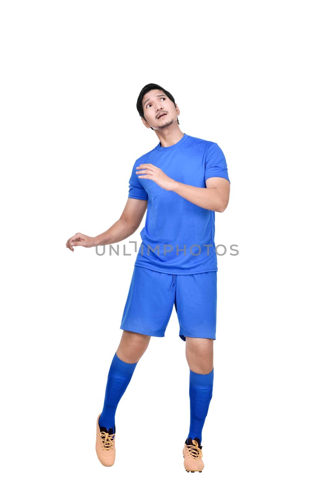 Attractive asian male soccer player heading the ball isolated over white background