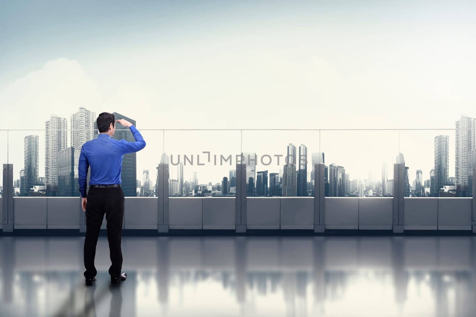 Young asian businessman looking at the cityscape from office terrace