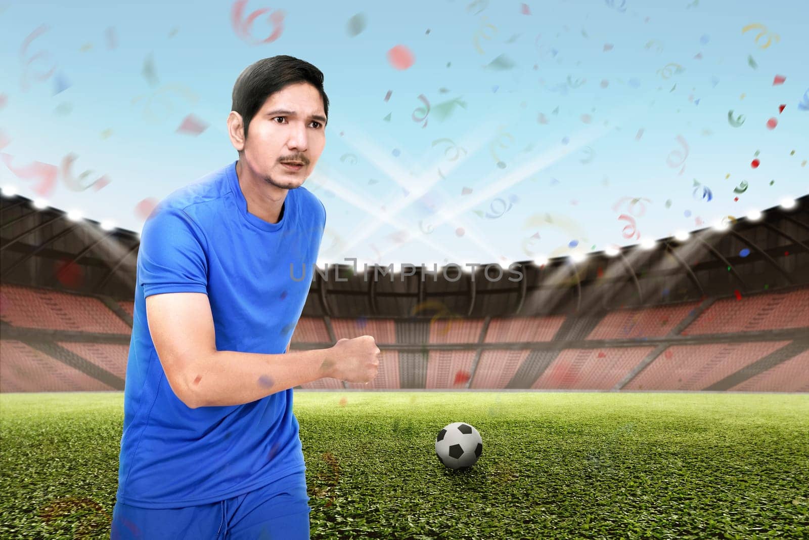 Young asian football player man playing the ball on the field