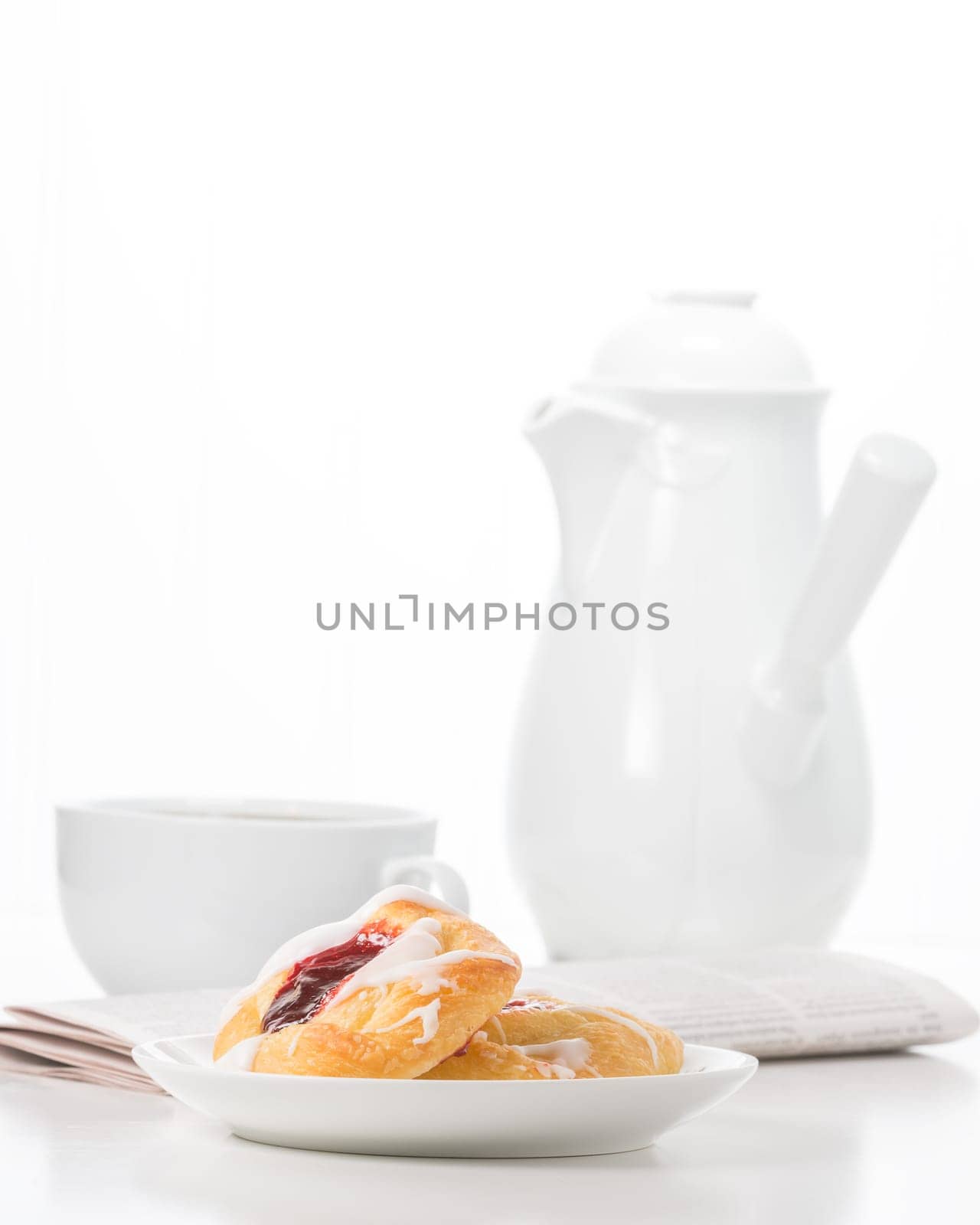 Breakfast consisting of raspberry danish and coffee.