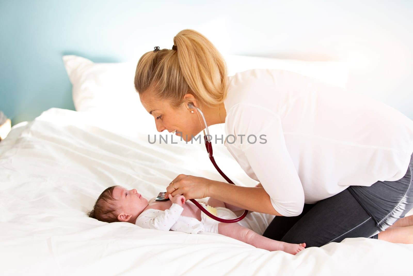 Pediatrician examines baby with stethoscope at home