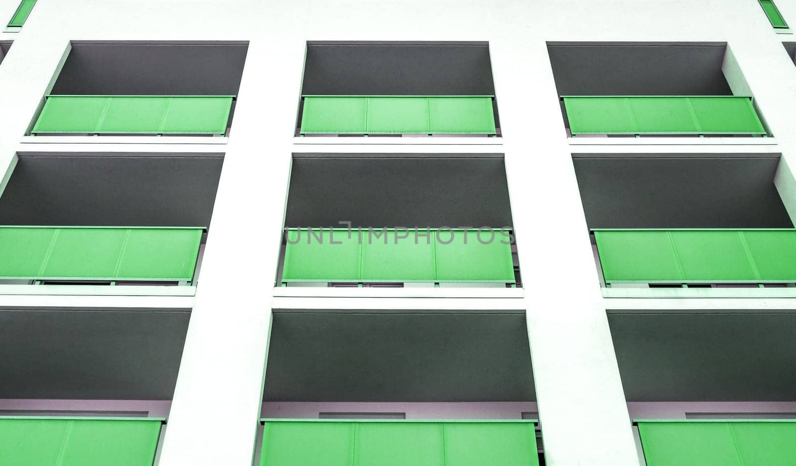 White living house with appartments and green balconies