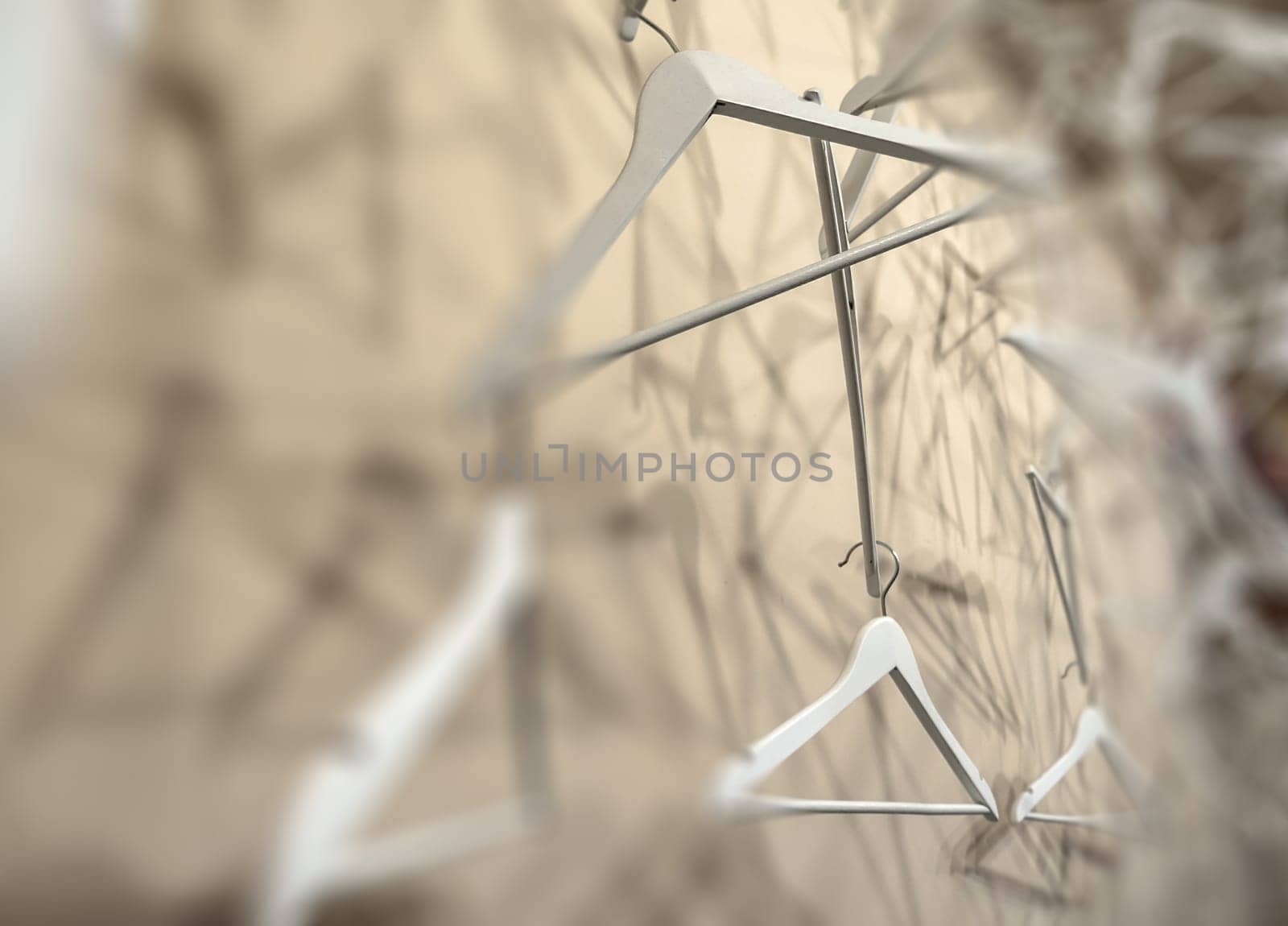 Empty wooden clothes hangers casting deep shadows. Real coat hanger wood pattern. Abstract fashion concept. Selected focus.