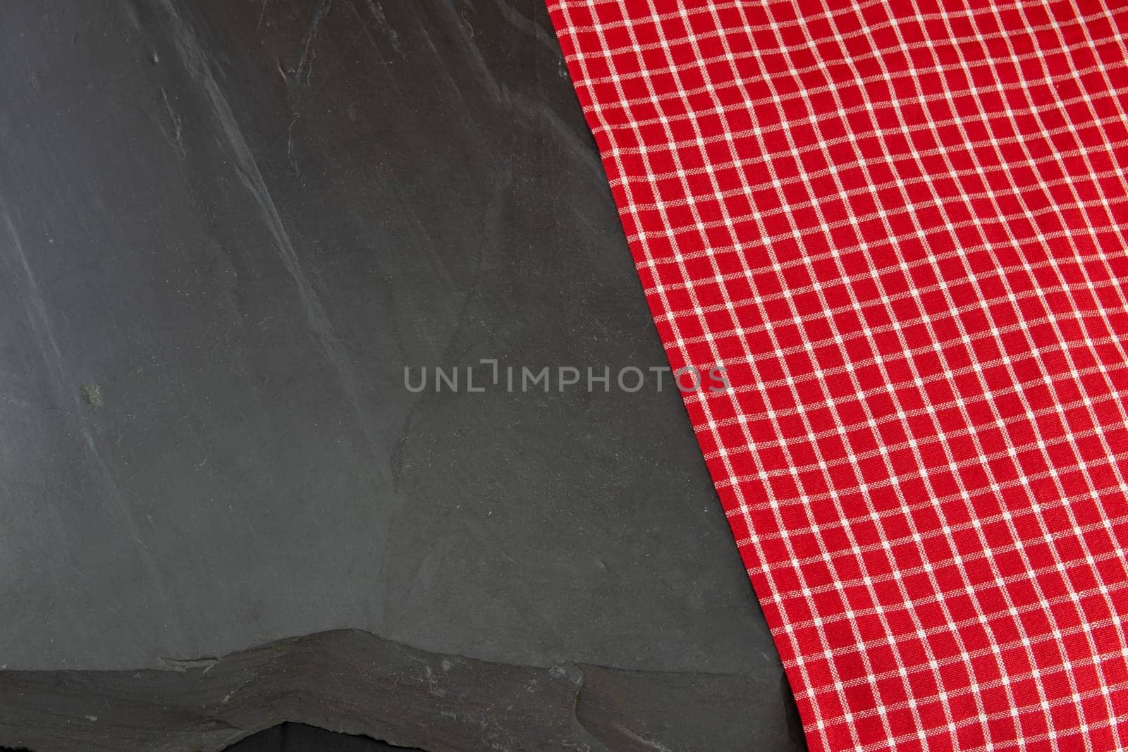 Red checkered tablecloth on massive slate plate. Template for design menu card and chalkboard. Space for designer.