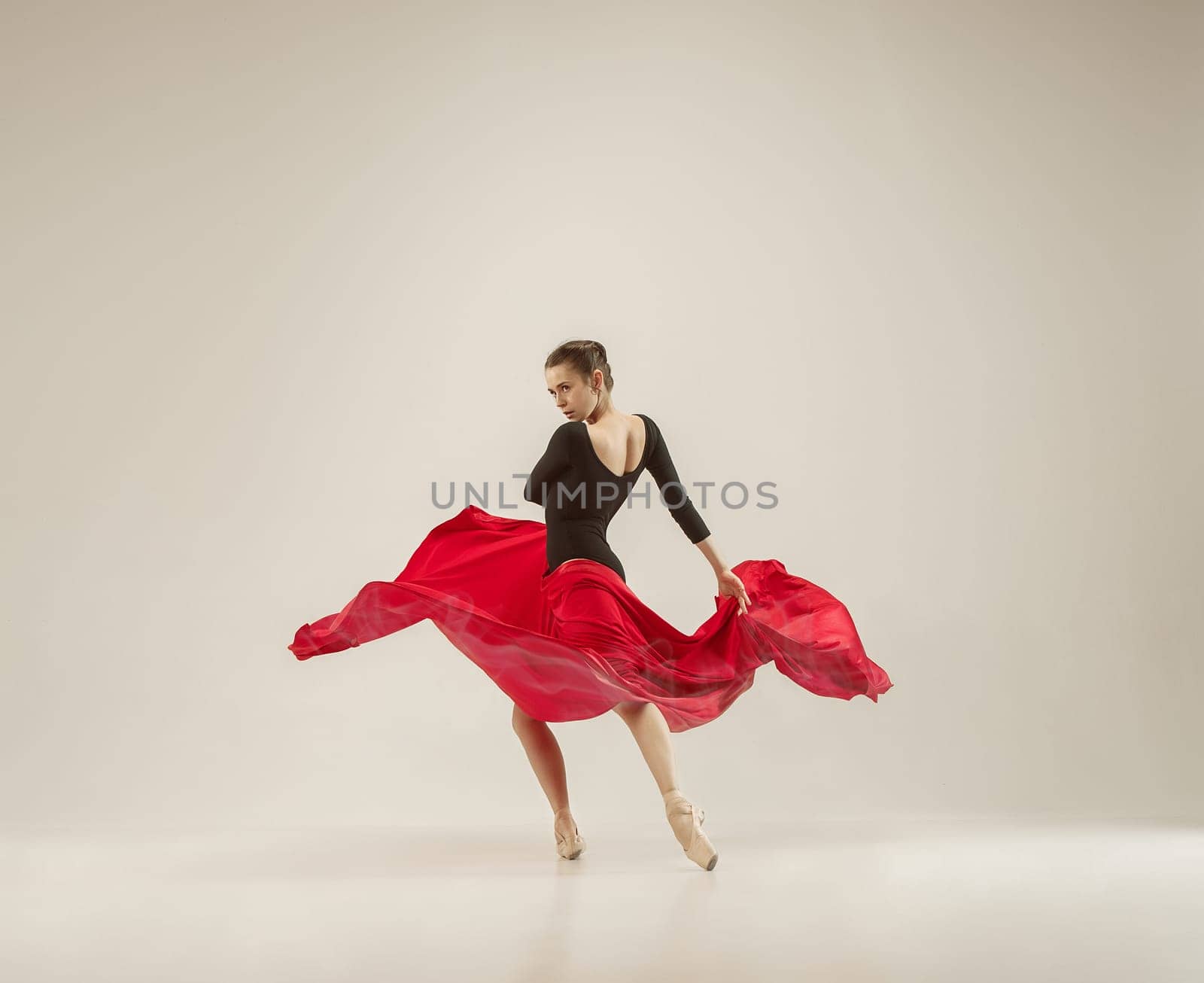 Modern ballet dancer exercising in full body on white studio background. Ballerina or female dancer with silk fabric dancing on white studio background. Caucasian model on pointe shoes