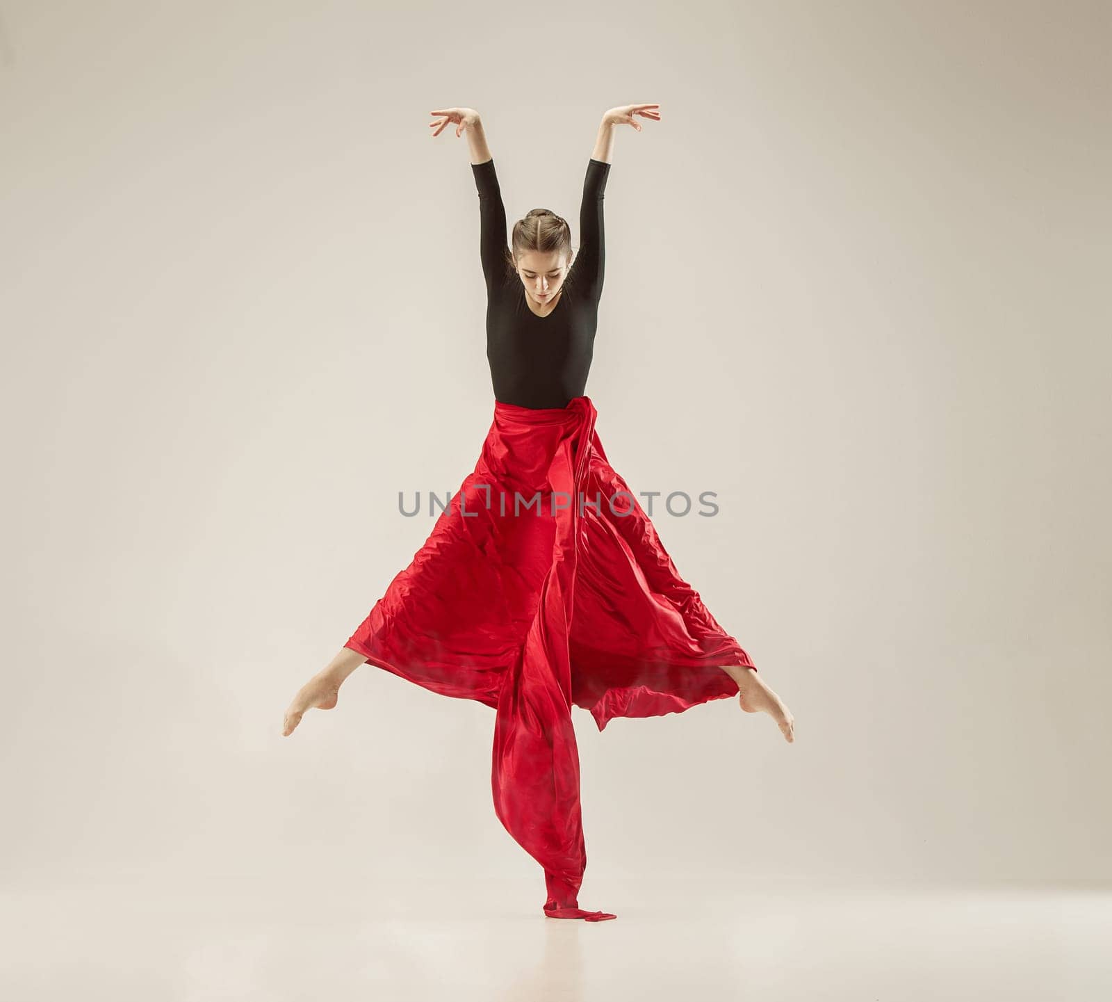 Modern ballet dancer exercising in full body on white studio background. Ballerina or female dancer with silk fabric dancing on white studio background. Caucasian model on pointe shoes