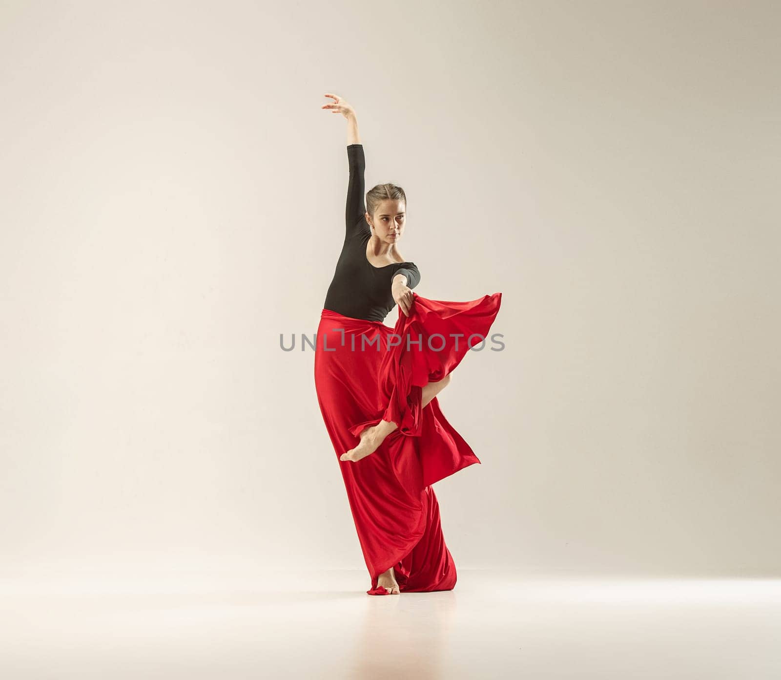 Modern ballet dancer exercising in full body on white studio background. Ballerina or female dancer with silk fabric dancing on white studio background. Caucasian model on pointe shoes
