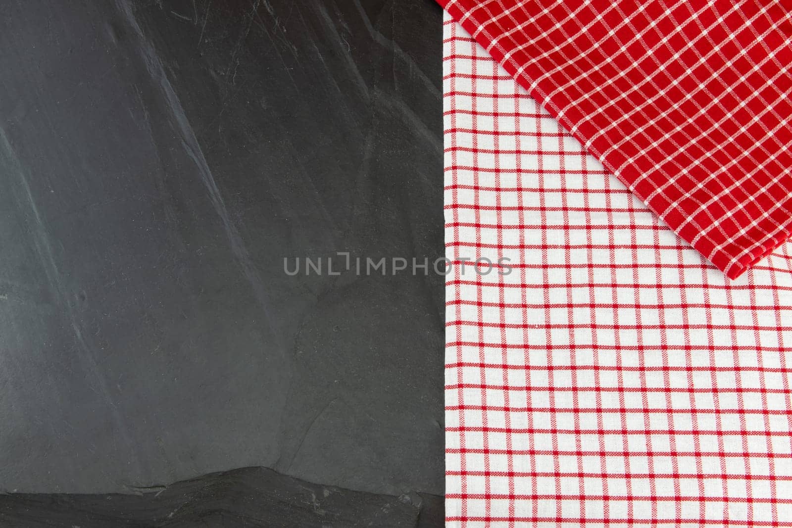 Red and white checkered tablecloth on massive slate plate. Template for design menu card and chalkboard. Space for designer.