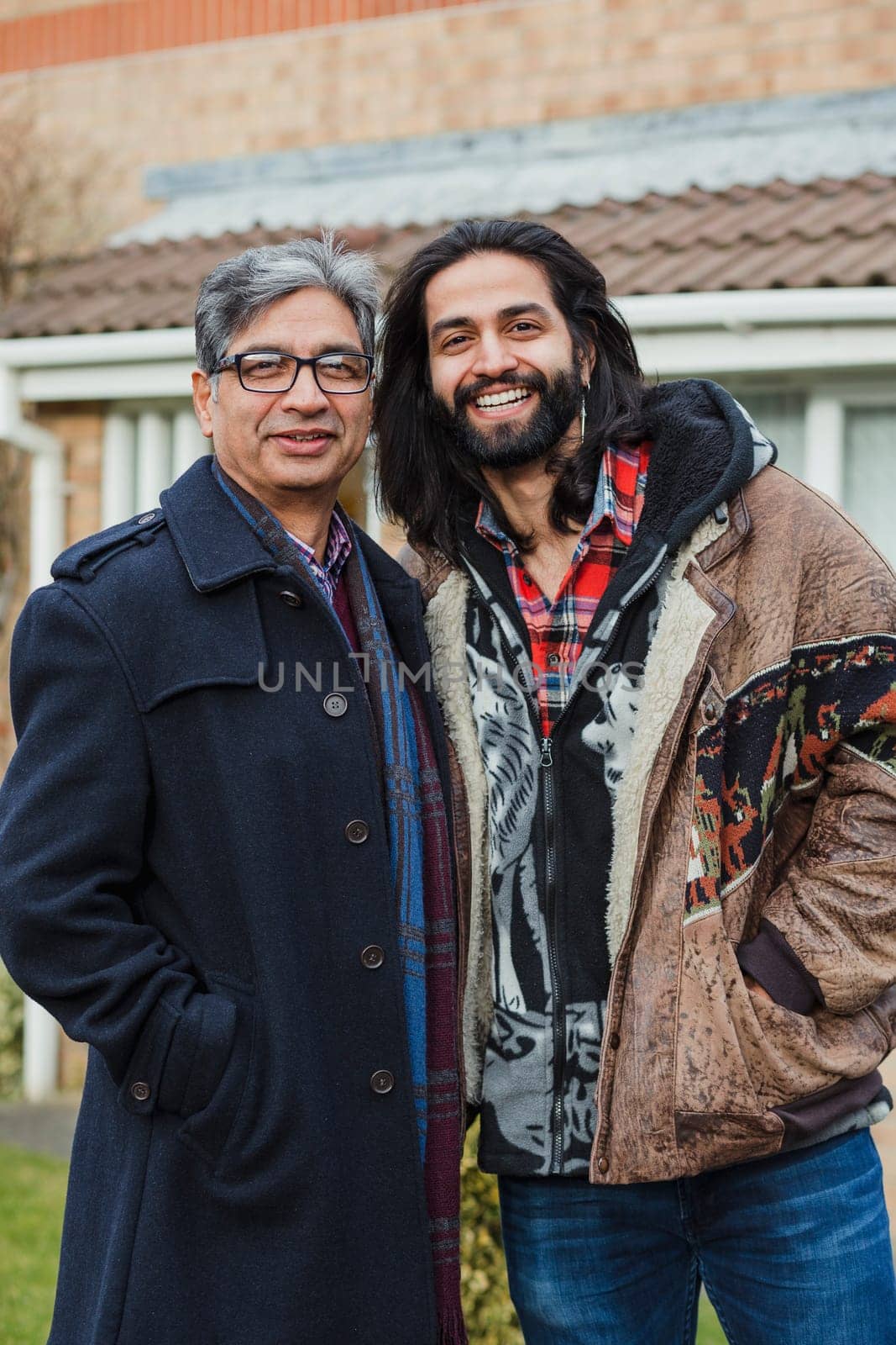portrait of a happy father and his son on the driveway of their home.