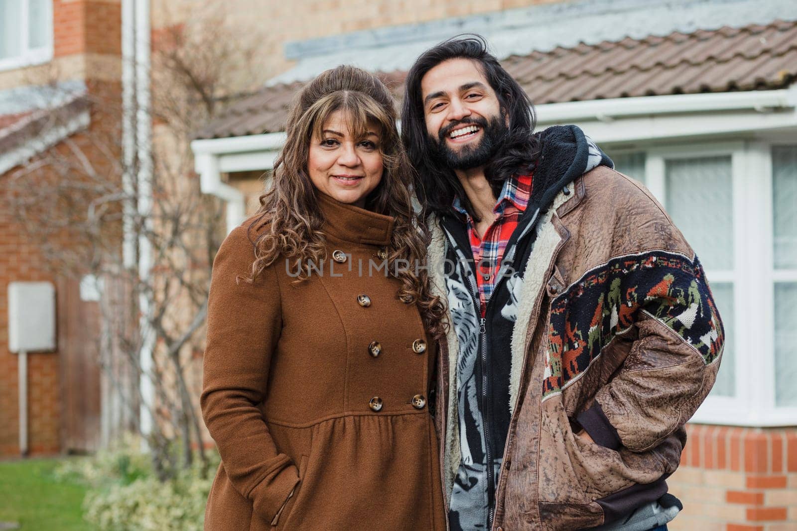 Portrait of a happy mid adult man and his mother on the driveway of their home.