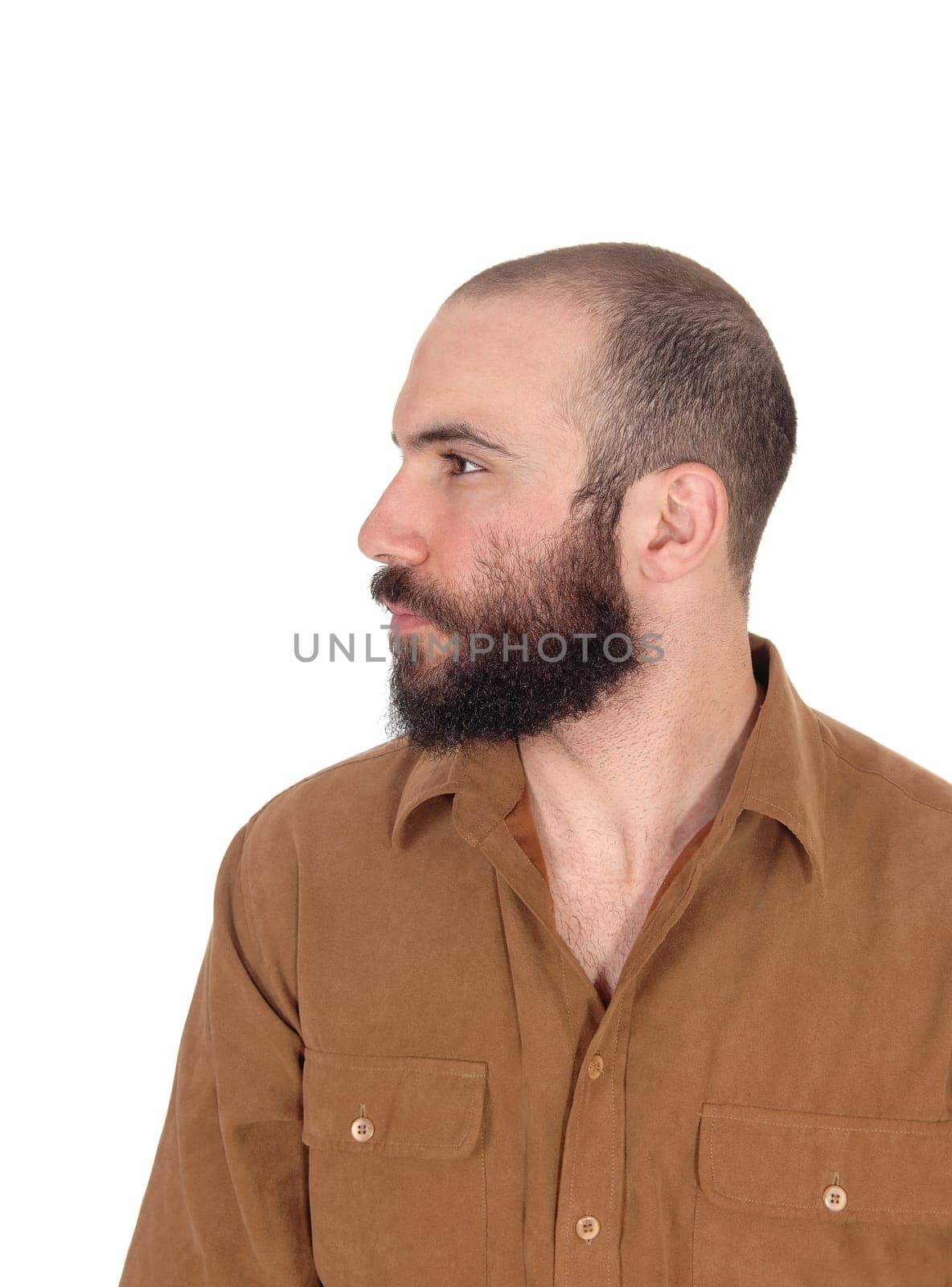A portrait image of a young man in a brown shirt with short hair and.beard and mustache looking away, isolated for white background.